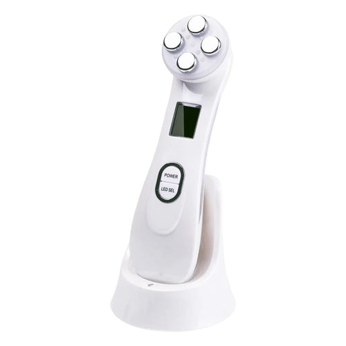 NuLifeBeauty 5-in-1 facial EMS device with 4 metal electrodes and an LCD screen, standing on its charging base